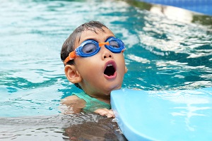 Child in swimming pool wearing goggles