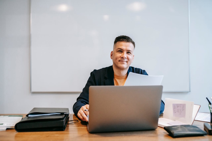 Man smiling while using a laptop