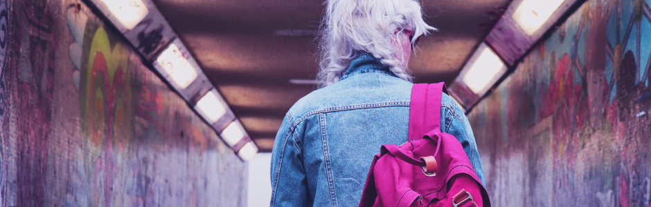 Girl with a rucksack standing at the entrance to an underpass tunnel