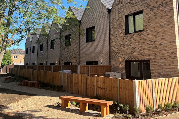A bench on a path running alongside newly built council homes
