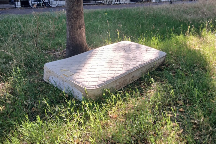 A mattress that has been left on a park