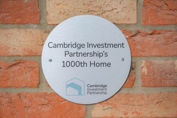 Commemorative plaque reads 'Cambridge Investment Partnership's 1000th home'