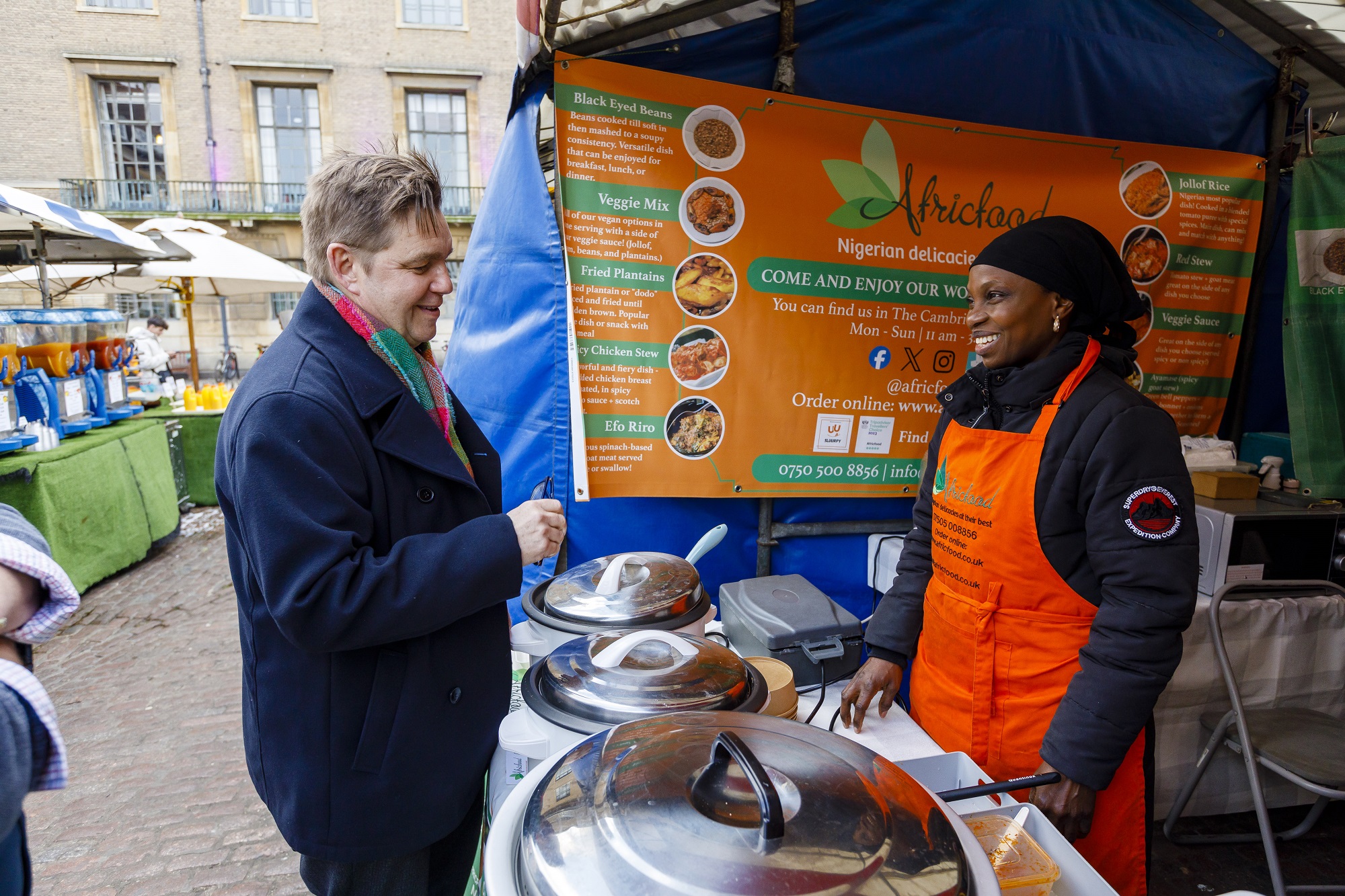Mayor of Cambridgeshire and Peterborough left, at AfricaFood stall on Cambridge Market Square