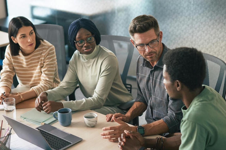A diverse group of people meeting around a table