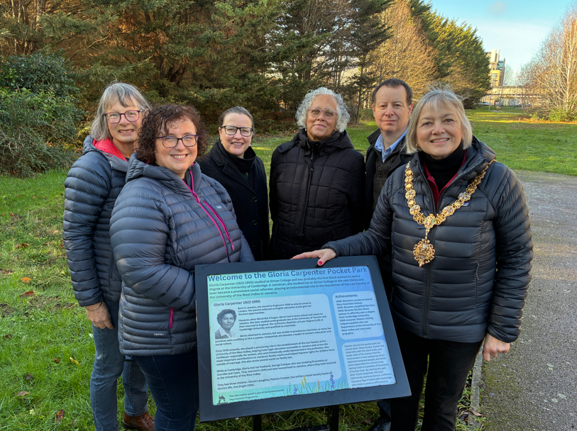 A group of people in front of an information board at Gloria Carpenter Pocket Park in Cambridge